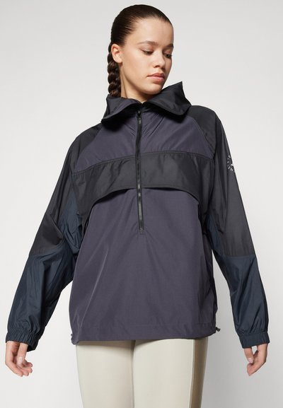 Manteau léger et sombre avec une demi-fermeture éclair, un col haut et des poignets élastiques. Présente un design à panneaux contrastants et une coupe décontractée.