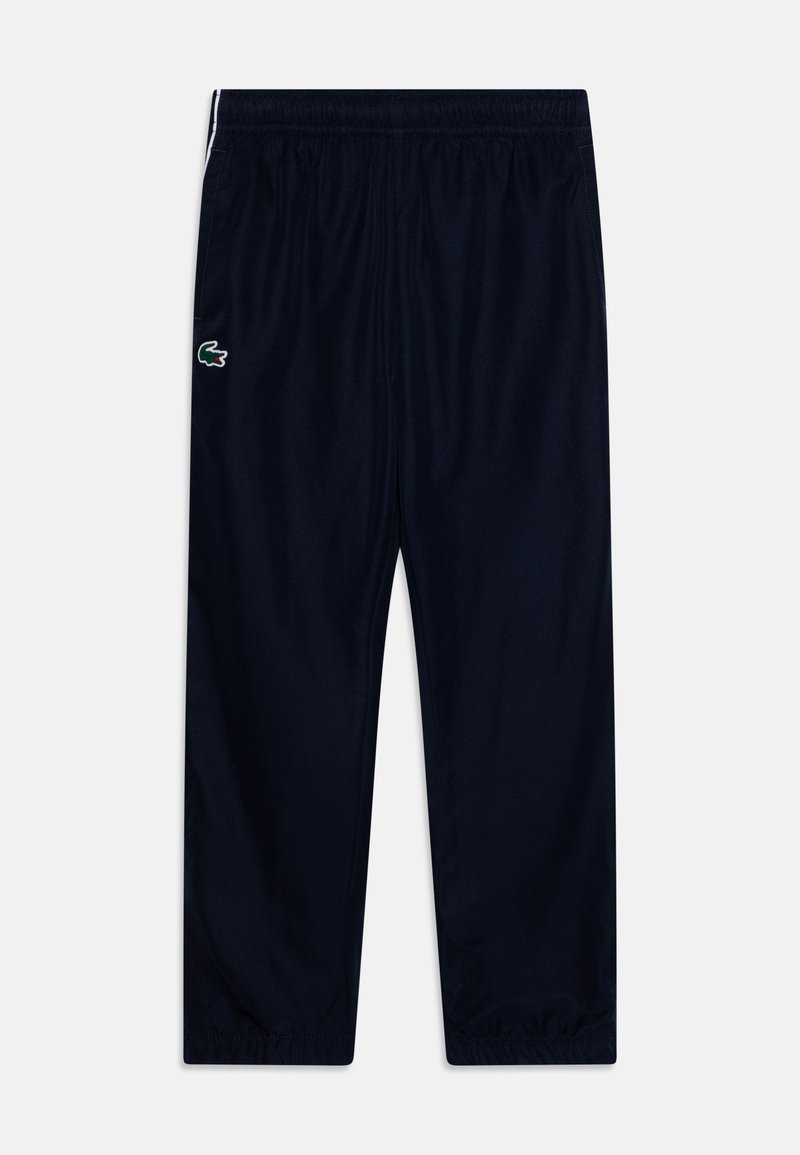Marinefarbene Sporthosen aus leichtem Stoff, mit elastischem Bund, seitlichen Taschen und einem kleinen grünen Logo auf der linken Seite.