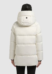 Biela prešívaná bunda s kapucňou, s prešívaným dizajnom a okrúhlym čiernym gombíkom na zadnej strane. Hladký, lesklý materiál.