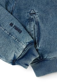 Jeansjacke mit einem verblassten blauen Finish, gerippten Bündchen und Seitentaschen. Mit besticktem Text 'DO THINGS' in dunkelblau am Ärmeln.