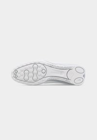 Σόλα ενός λευκού παπουτσιού Nike που δείχνει υφασμένη πρόσφυση με κυκλικά και οβάλ μοτίβα και το κείμενο "NIKE SWOOSH" σε απλή επιφάνεια.