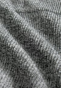 Hustá, žebrovaná tkanina v odstínech šedé s texturovaným povrchem. Materiál vypadá měkce a pružně, vhodný na oděvy nebo čalounění.
