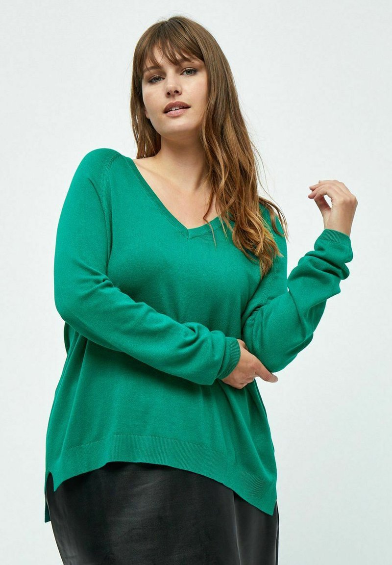 Maglione verde a V in morbido tessuto a maglia, con maniche lunghe, vestibilità rilassata e orlo arrotondato con spacchi laterali.