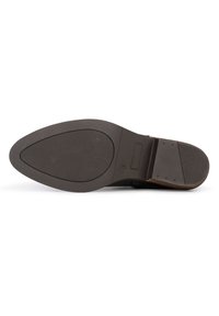 Suela de zapato de goma marrón con una superficie texturizada, que presenta una forma alargada y un ligero tacón. Incluye una impresión de logo y agujeros de drenaje.