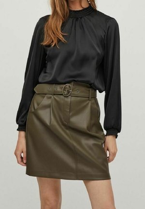 Sort satin langærmet bluse med en smocket halsudskæring, parret med en olivengrøn faux læder nederdel med et spænde bælte og frontfolder.