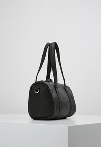 Czarna skórzana torebka o zaokrąglonym kształcie, z podwójnymi uchwytami i gładką fakturą. Posiada metalowy srebrny detal w postaci pierścienia z jednej strony.