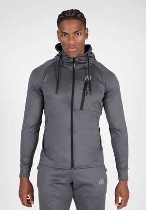 Grijze zip-up hoodie met een slanke pasvorm, gemaakt van een gladde stof. Voorzien van een voorzak met rits en een capuchon, geaccentueerd met een logo op de borst.