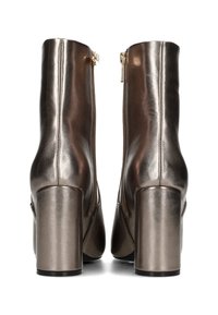 Metallic bronze ankle boots with a sleek design, featuring a high square heel and zip closures on the back. Smooth texture, no visible patterns.