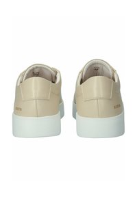 Beige leather sneakers with a smooth finish, rounded toe, and white rubber sole. Rear features minimalist branding and subtle stitching details.