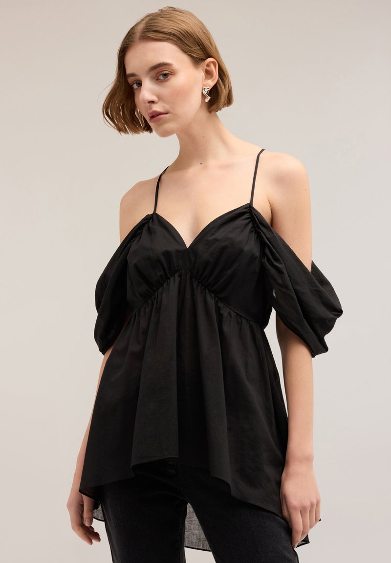Top nero off-the-shoulder con corpetto attillato, maniche a sbuffo e orlo fluente. Realizzato in tessuto liscio, presenta un design con scollo a V profondo.