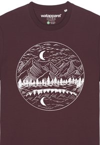 Burgunderfarbendes Baumwoll-T-Shirt mit einem weißen runden Druck, der Berge, Bäume und einen Mond zeigt und eine reflektierende Landschaft darstellt.