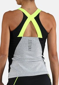 Schwarzes und graues Sporttanktop mit neon-gelben Trägern. Verfügt über einen gekreuzten Rücken und den Aufdruck "ENDLESS" entlang des grauen Abschnitts.