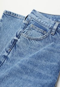 Jeans de mezclilla azul claro con una textura suave, que cuentan con un diseño de cinco bolsillos y una cinturilla visible con detalles de costura.