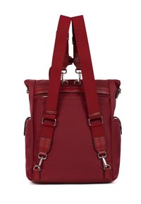 Zaino in tessuto rosso con spallacci imbottiti e regolabili, tasche con cerniera e dettagli in metallo argentato. Il design accentua la forma verticale e la trama liscia.