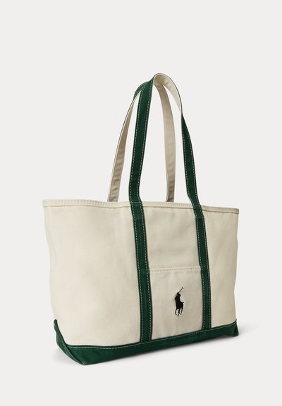 Beige canvas draagtas met donkergroene handvatten en bodem, voorvak en zwarte geborduurde polo speler logo op het voorvak.