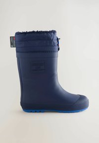 Botte de pluie en caoutchouc marine avec une semelle texturée bleue, un bord en tissu rembourré et un patch logo. Présente un cordon décoratif en haut.