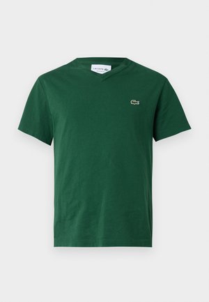 T-shirt di cotone verde con scollo a V, maniche corte e un piccolo logo ricamato sul lato sinistro del petto. Tessuto liscio, vestibilità casual.