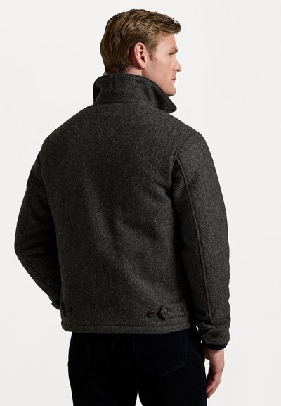 Dark gray wool jacket with a high collar, prominent stitching, and button accents, shown from the back, highlighting its robust texture.
