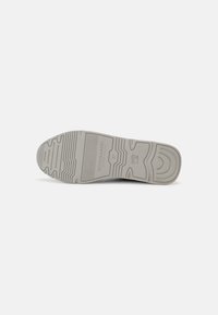 Semelle d'une chaussure gris clair montrant un motif texturé, le nom de la marque Scotch & Soda, la taille 37 et le logo sur un fond blanc uni.