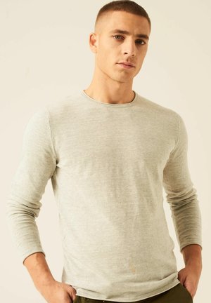 Camisa de manga larga gris claro en un tejido acanalado con cuello redondo. La tela parece suave y ligera, con mangas ajustadas.