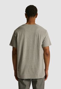 Szara bawełniana koszulka z okrągłym dekoltem i krótkimi rękawami, charakteryzująca się gładką fakturą i luźnym krojem, widoczna z tyłu.