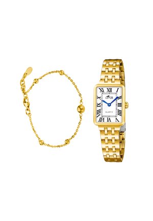 Zapestnica v zlati barvi z majhnimi okroglimi kroglicami in nastavljivo verižico ob zlati pravokotni ročni uri z rimskimi številkami in modrimi kazalci.