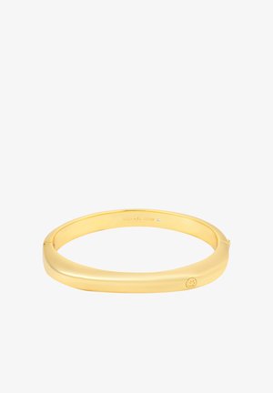 Armband van metaal met goudkleurige afwerking en een glad, gebogen ontwerp. Aan de binnenkant voorzien van merkopdruk en een klein accentdetail. Gepolijste afwerking.