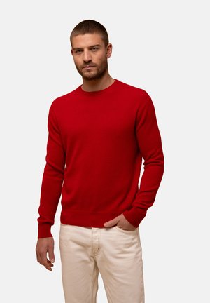 Rode gebreide sweater met een ronde hals, lange mouwen en geribbelde boorden en onderkant. Draag met een witte broek, heeft een gladde textuur.