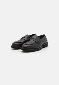 Sorte lær loafers med en glatt finish, som har en sydd detalj og en lett hevet svart såle. Klassisk slip-on design.
