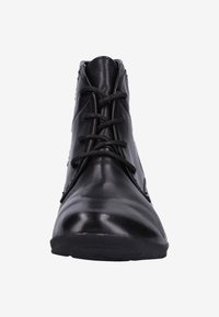 Botín de cuero negro hasta el tobillo con punta redondeada, textura suave, diseño con cordones y detalles minimalistas. Suela plana de goma.