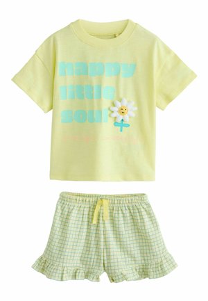 Yellow short-sleeve shirt with "happy little soul" text and a smiling daisy, paired with yellow plaid ruffled shorts with drawstring waist.