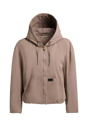 Lysebrun hættejakke med lynlås, snore i hætten, forlommekangaroo og et lille rektangulært mærke på lommen.