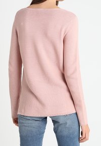 Pink ribbed sweater with a wide neckline and long sleeves, featuring a relaxed fit and straight hemline. Textured fabric is visible.