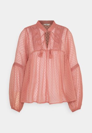 Peach pink blouse made of sheer, textured fabric, featuring a tie neck, embroidered yoke, and balloon sleeves with elastic cuffs.