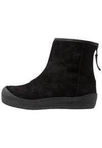 Des bottines en suede noir à bout rond, avec des panneaux élastiques sur les côtés et une semelle en caoutchouc texturée noire, dotées d'une fermeture éclair à l'arrière pour un enfilage facile.