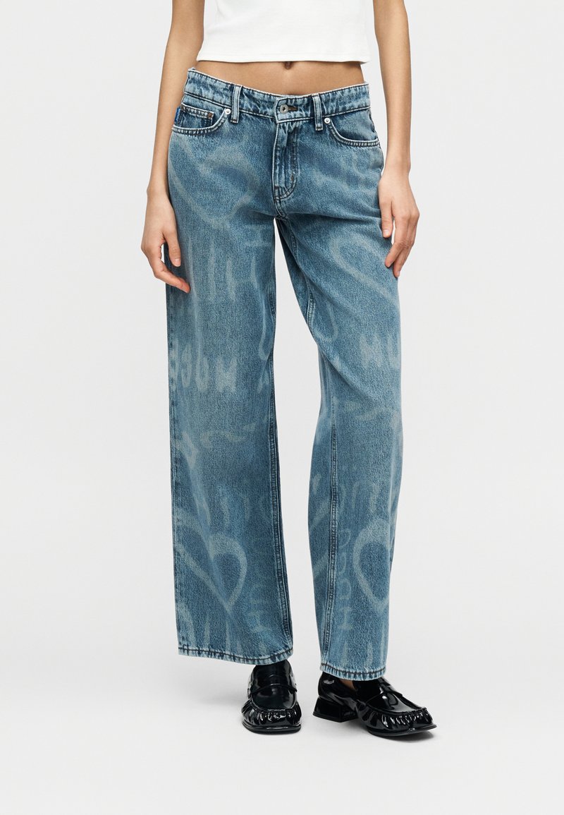 Φαρδιά τζιν παντελόνια σε ανοιχτό μπλε χρώμα με ξεθωριασμένο μοτίβο, πέντε τσέπες και αντίθετες ραφές. Μεσαία μέση και μήκος μέχρι τον αστράγαλο.