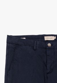 Pantaloni in cotone blu navy con vita piatta, chiusura a bottone, passanti per cintura e tasche laterali; texture opaca. Progettati per una vestibilità aderente.