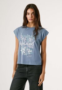 Īsām piedurkņu zils kokvilnas T-krekls ar baltu un gaiši zaļu ziedu grafiku, ar tekstu "Pepe Jeans London" centrā.