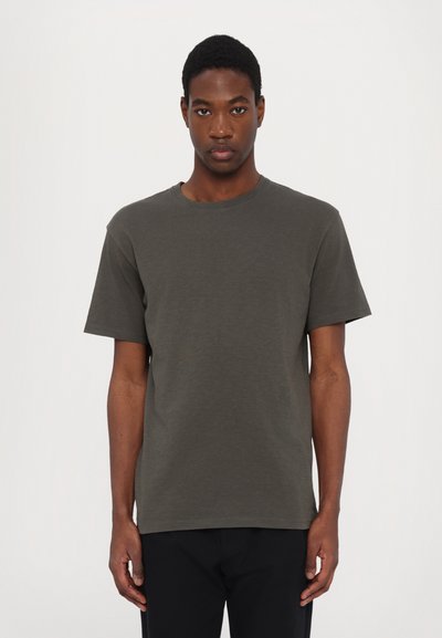 Tricou cu mânecă scurtă dintr-un material de culoare verde măsliniu închis, cu guler rotund și croială lejeră. Detaliu discret cu logo aproape de tiv. Textură netedă.