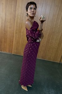 Bordó kötött ruha arany pöttyökkel, vállvillantós kialakítással, texturált anyagból és hullámos szegéllyel, párosítva hegyes orrú, bézs magassarkúval.