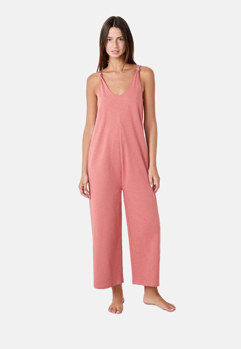 Mono de algodón rosa con escote en V, tirantes ajustables con lazo y piernas anchas, que presenta un ajuste relajado y una textura suave.