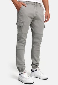 Graue Cargo-Hosen mit schmaler Passform, elastischen Bündchen, mehreren Seitentaschen und einem weichen Materialmix aus Baumwolle und Polyester.