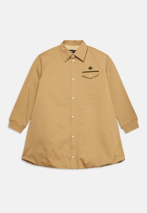 Chemise à manches longues couleur fauve avec col pointu et une seule poche poitrine ornée d'un petit emblème de feuille d'érable.