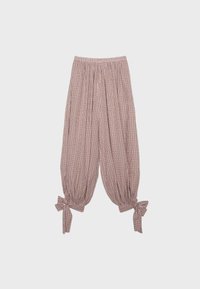 Pantalon ample à carreaux avec taille élastique et liens aux chevilles dans des tons rose pâle et blanc sur fond clair.