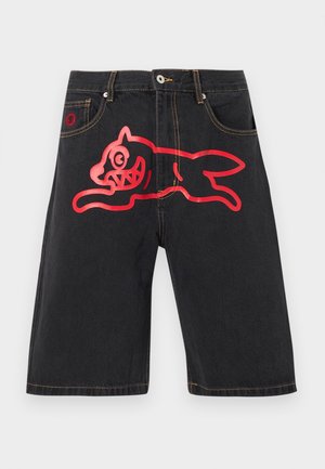 Black denim shorts with yellow stitching and large red outline of a running cartoon dog across the front.