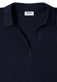 Granatowa koszulka polo od CECIL z usztywnionym kołnierzykiem, półguzikową listwą i teksturowanym materiałem. Czysty design, bez wzorów ani dodatkowych akcentów.