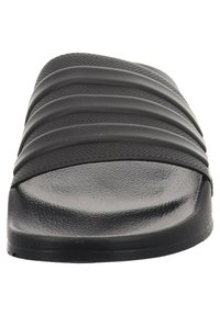 Black slide sandal featuring a smooth textured footbed, wide strap with horizontal ridges, and a low-profile design.