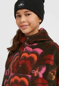Pull en polaire marron avec des motifs floraux colorés en rose, orange et rouge. Il dispose d'une capuche et de boutons-pression. Logo O'Neill brodé.