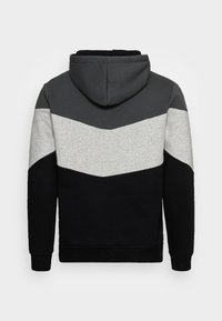 Sudadera con capucha que presenta un diseño de chevron en negro, gris y gris claro, confeccionada en un tejido suave con puños y dobladillo acanalados.
