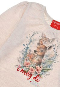 Helles rosa T-Shirt mit rundem Halsausschnitt, das einen zentralen Druck eines Rehs zeigt, umgeben von Blumen und dem Text "i mog di" in Rot.